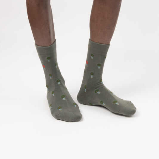 A model in green crew socks with a small green and red button pattern, photographed against a clean white studio background.