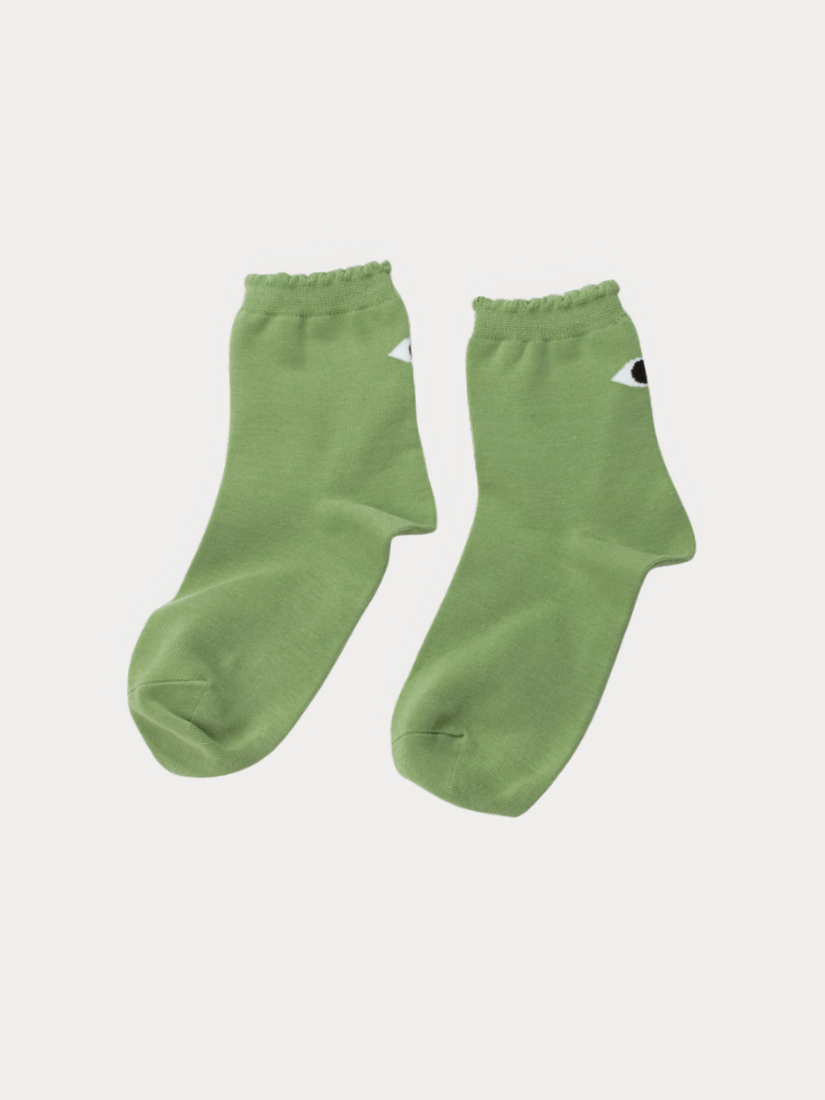 A pair of light green crew socks with a small white and black eye graphic on the side, displayed against a light gray background.