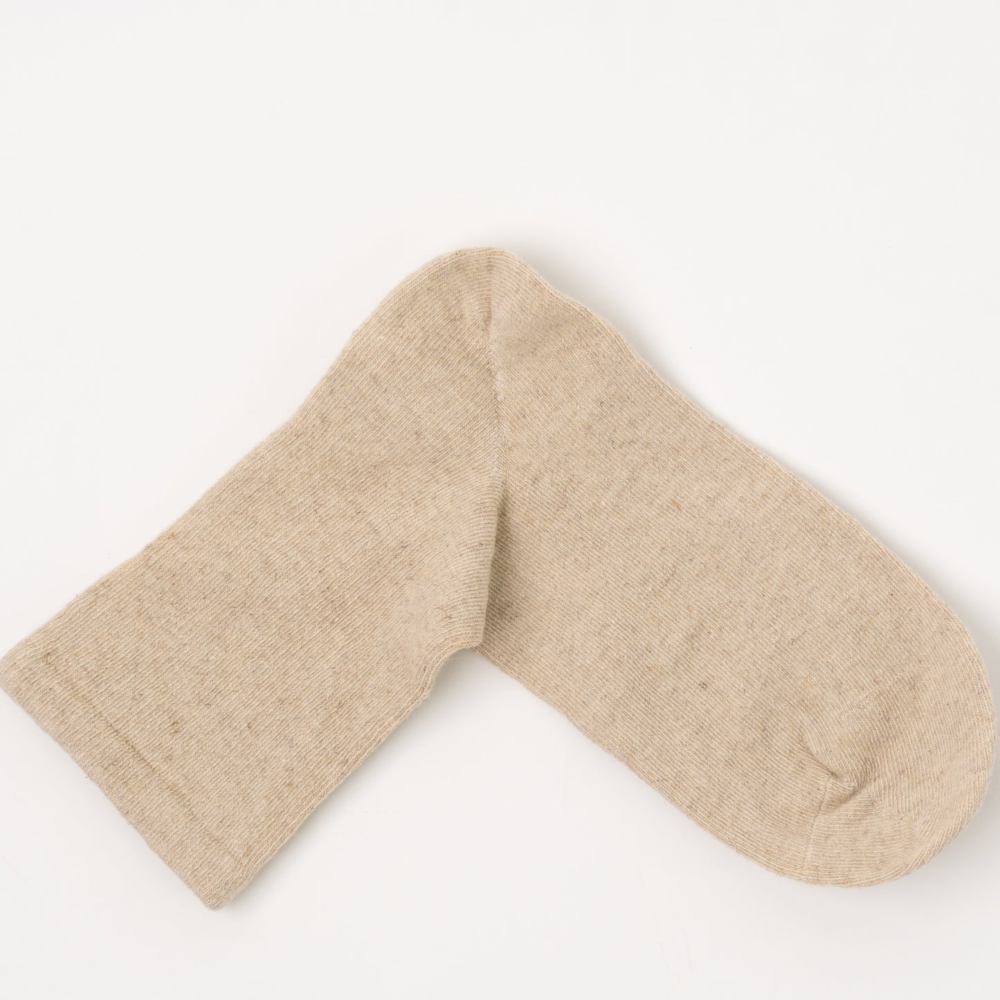 A single light beige knit sock laid flat on a clean white background.