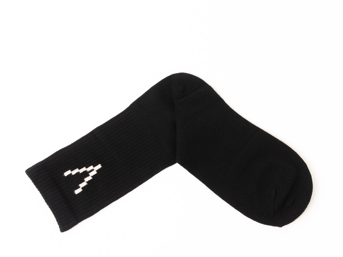 A single black ribbed knit sock with a white geometric V logo on the cuff, displayed on a clean white background.
