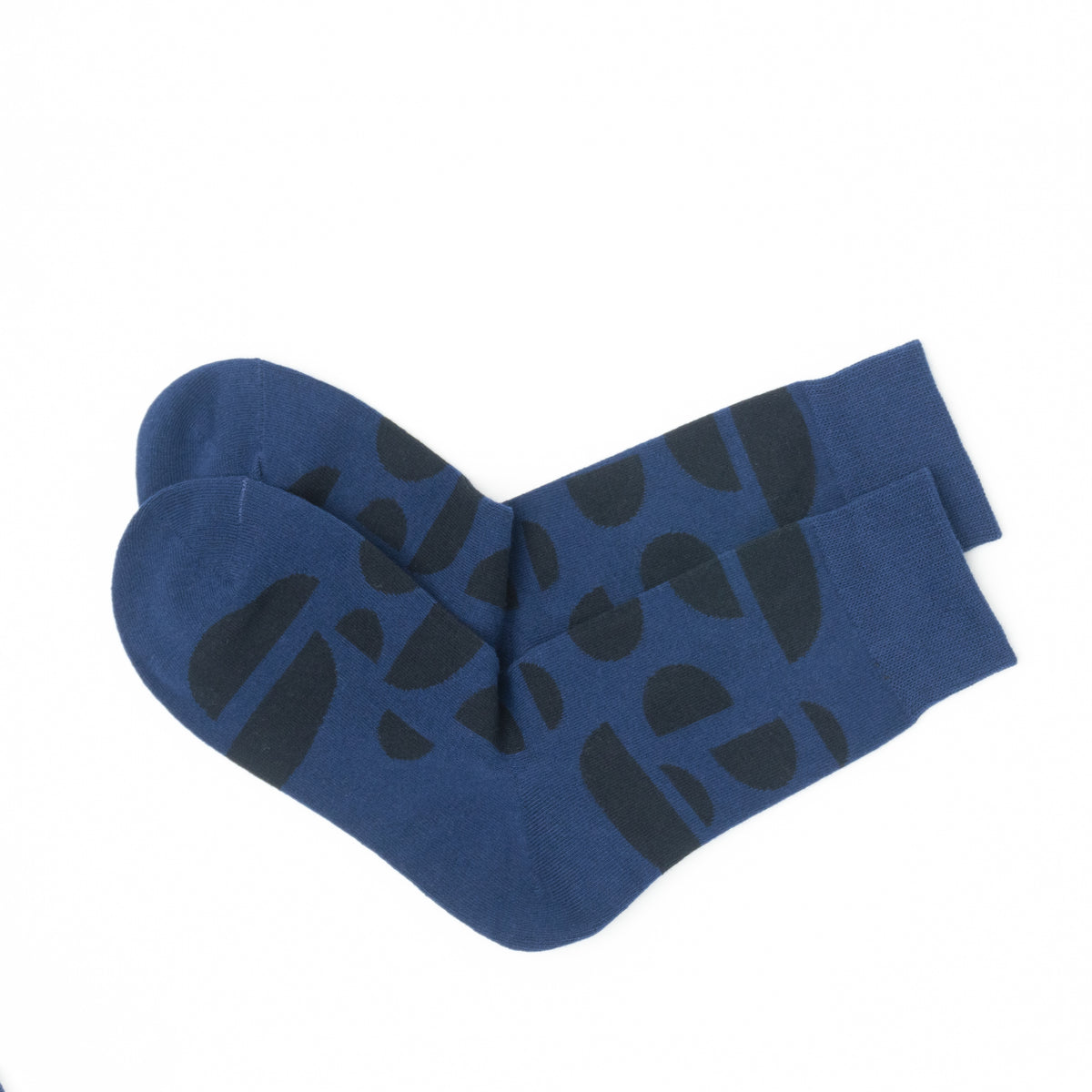 Pair of navy blue crew socks folded together, showing the dark abstract half-circle pattern from heel to toe.
