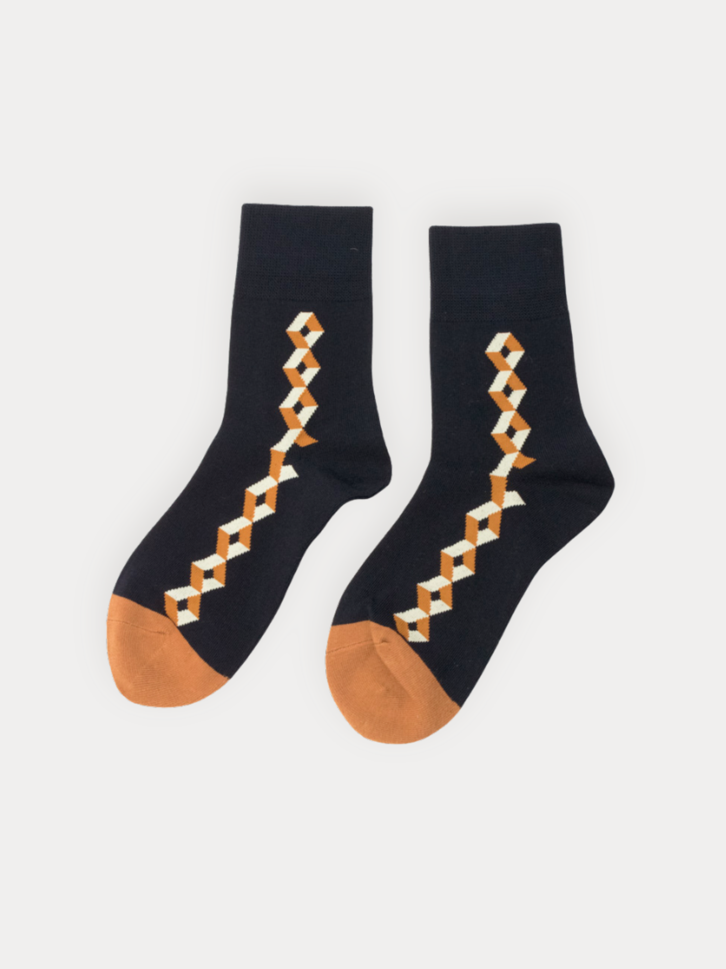 A pair of black crew socks with an orange and white geometric chain pattern down the leg and an orange toe.