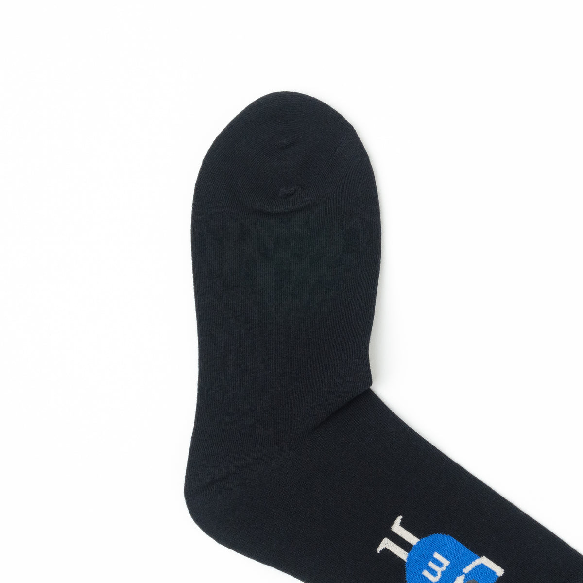 Close-up of the plain black toe of a crew sock, with the blue cartoon figure graphic visible near the cuff.