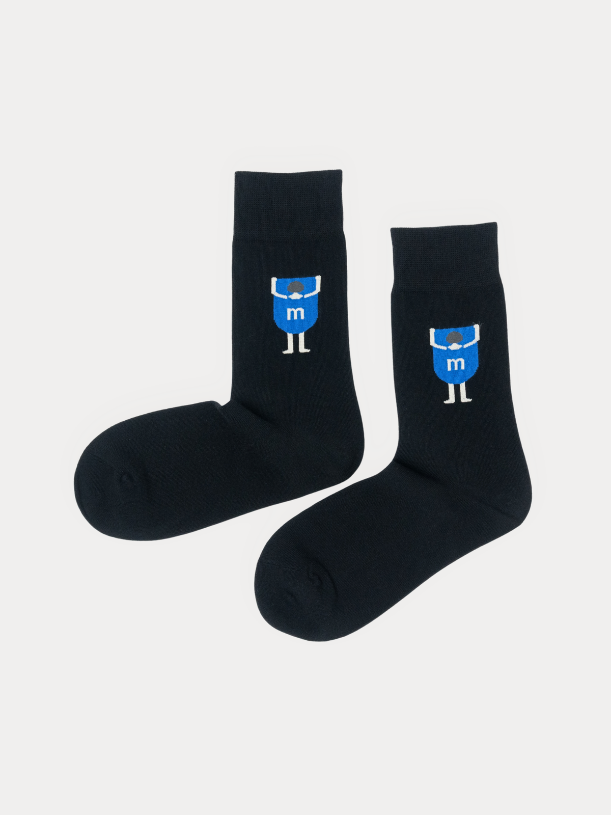 Pair of black crew socks with a blue cartoon figure graphic, laid flat side by side.