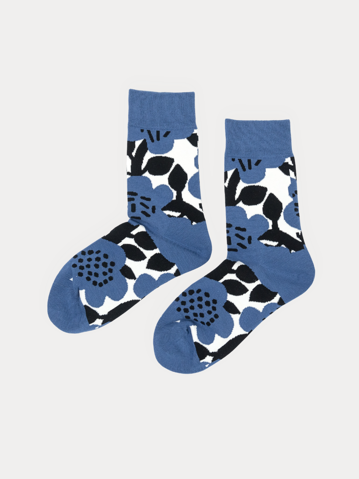 Pair of blue crew socks with a bold black and white floral print, laid flat side by side.