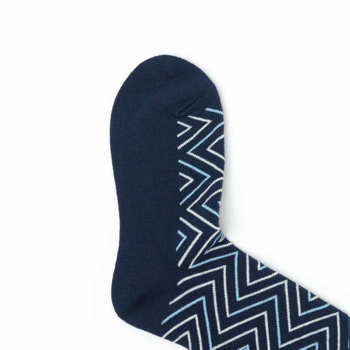 Close-up of the toe of a navy crew sock with a white and light blue chevron print.