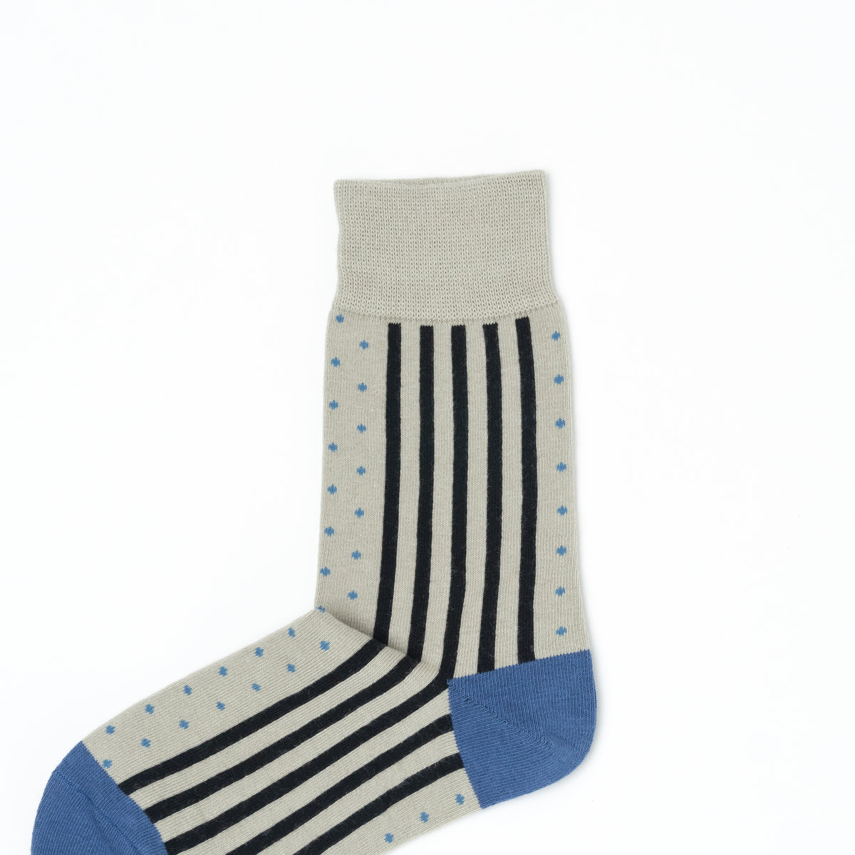 Close-up of a beige crew sock with a vertical stripe and dot pattern, blue heel and toe, and ribbed cuff.