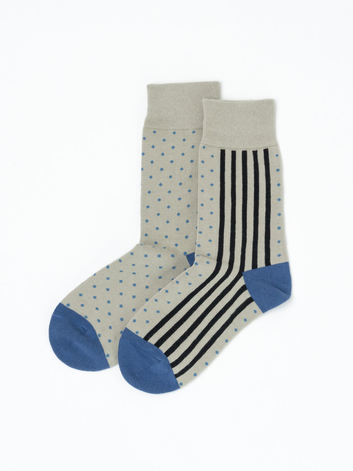 A pair of men's crew socks featuring a light beige base with blue polka dots on one leg, black and white vertical stripes on the other leg, and solid blue toes and heels, displayed on a clean white background.