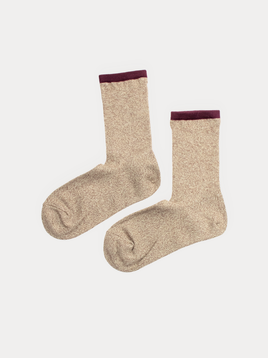 A pair of beige heathered crew socks with a contrasting dark burgundy cuff, displayed against a light gray background.