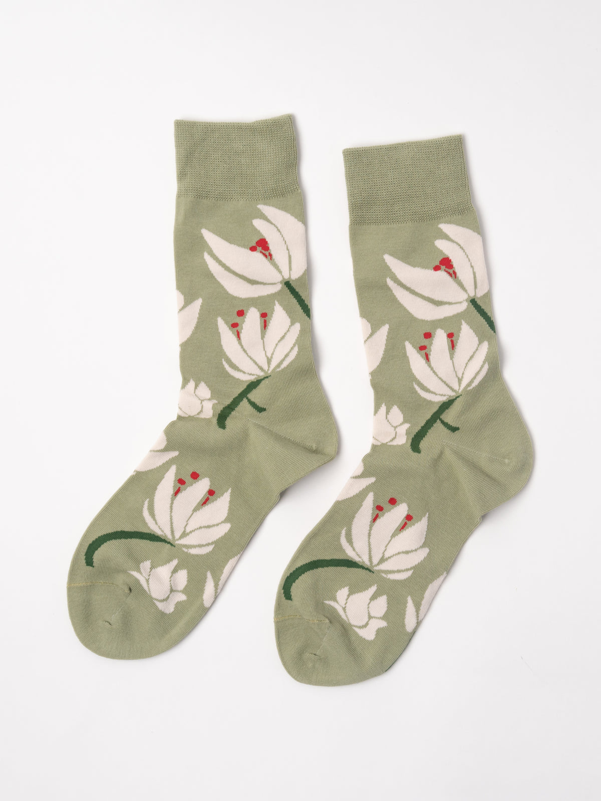 A pair of sage green crew socks with a white-and-green floral lotus pattern, displayed flat against a clean white background.