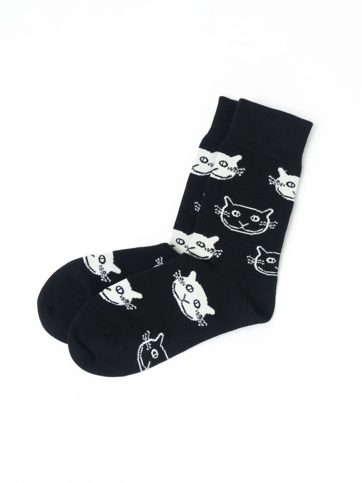 A pair of black crew socks with a white cartoon cat face pattern, displayed on a clean white background.