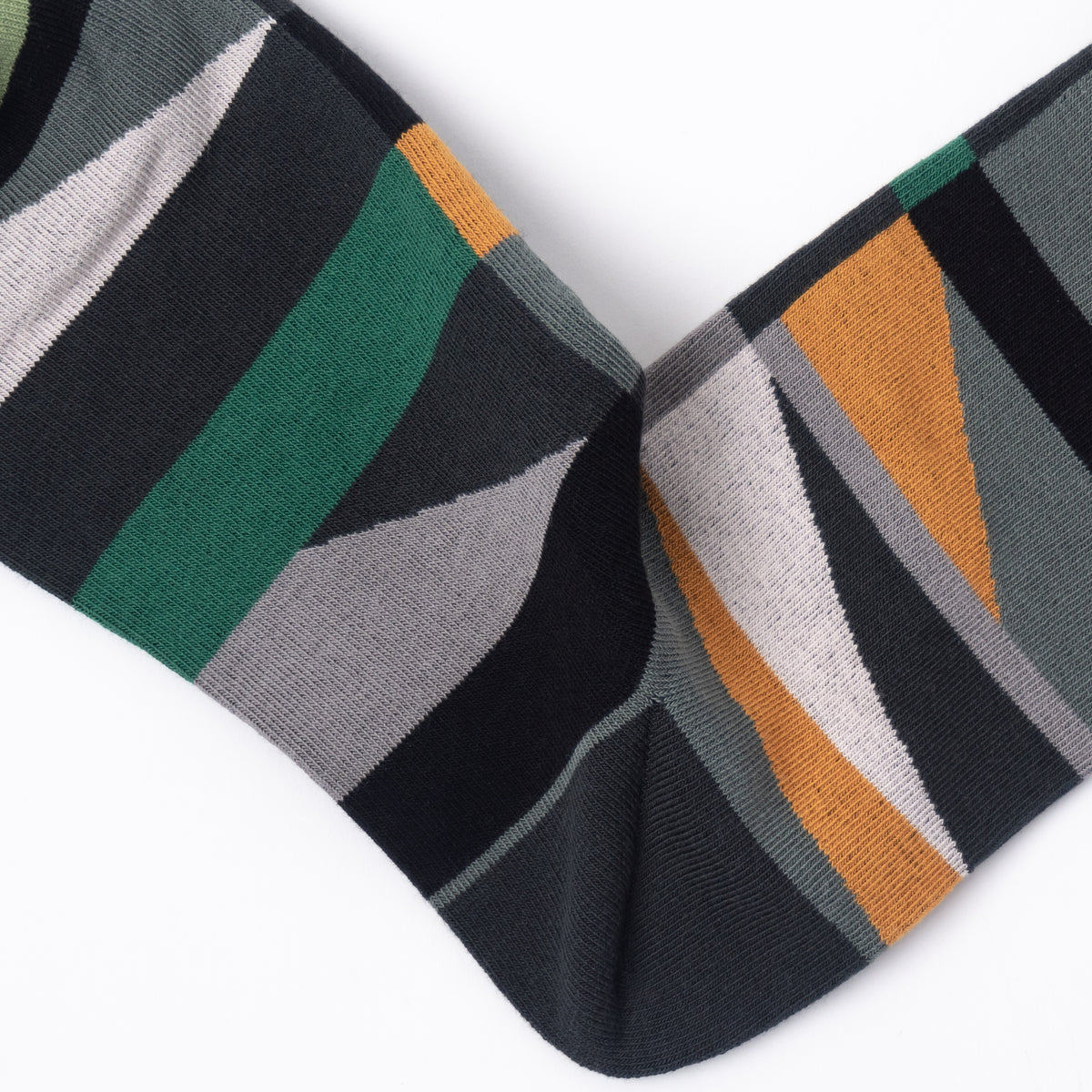A close-up of a single sock with a geometric striped pattern in black, dark green, gray, light gray, and orange on a white background.