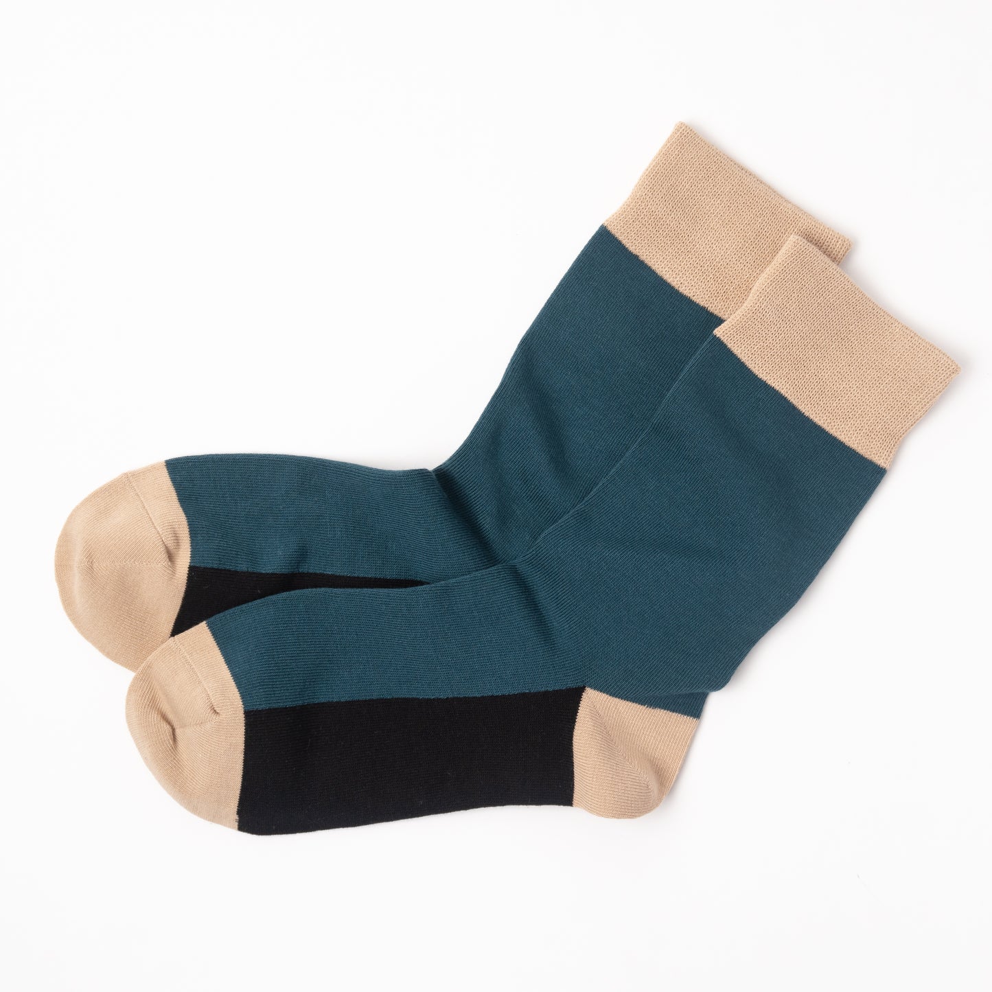 A pair of crew socks with a color-blocked design featuring a dark teal upper, a black toe section, and beige heels, cuffs, and toes, displayed on a clean white background.