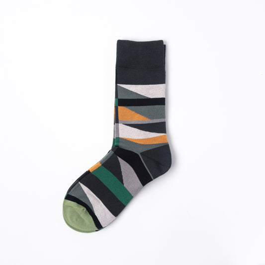 A single crew sock with a geometric pattern of diagonal stripes in dark gray, olive green, mustard yellow, light gray, and white, featuring an olive green toe cap, shown on a plain white background.