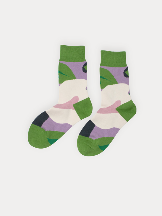 Pair of socks with green, white, and purple abstract pattern on a light gray background