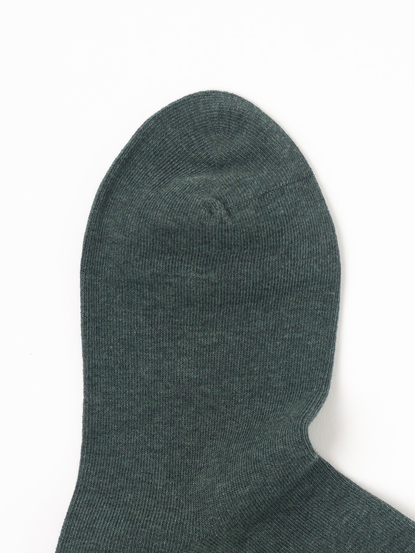 A close-up of a dark forest green ribbed knit sock on a plain white background.