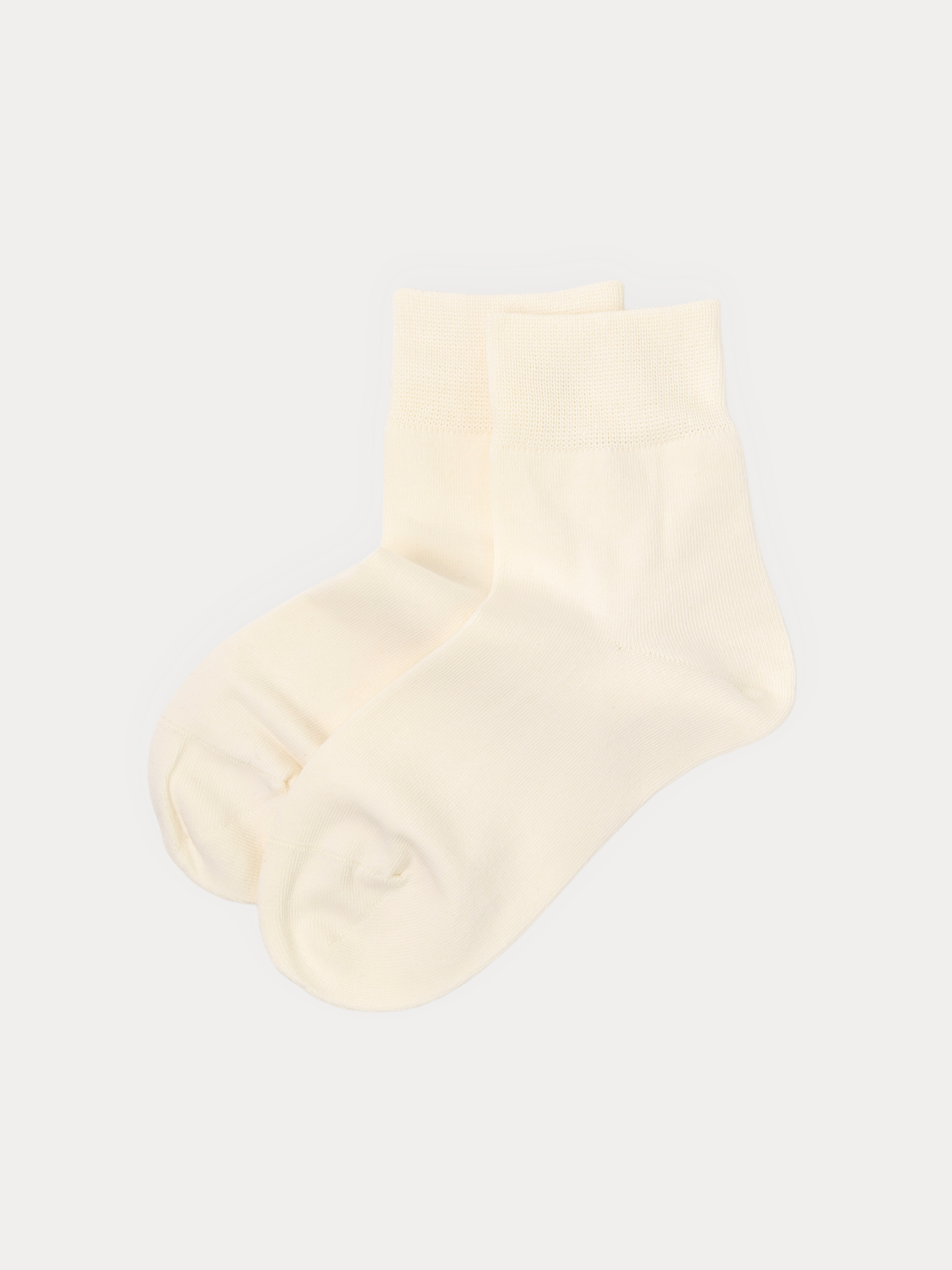 A pair of cream-colored quarter socks displayed against a light gray background.
