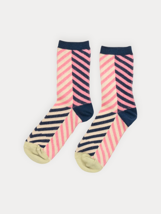 A pair of crew socks with a colorful striped pattern. The upper portion features diagonal stripes in pink and navy blue, while the lower portion has horizontal navy and cream stripes.