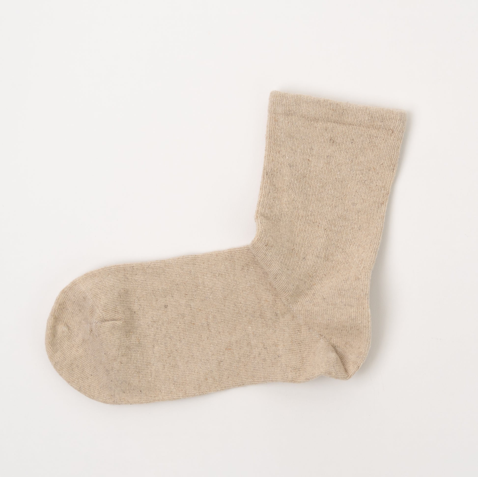 A single light beige knit sock laid flat on a clean white background.