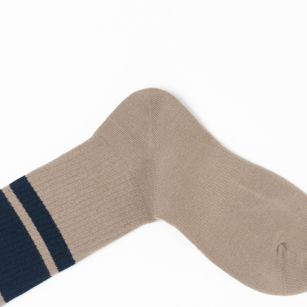 A single ribbed knit sock in a light taupe-beige color, featuring two dark navy blue horizontal stripes near the cuff, laid flat on a white background.
