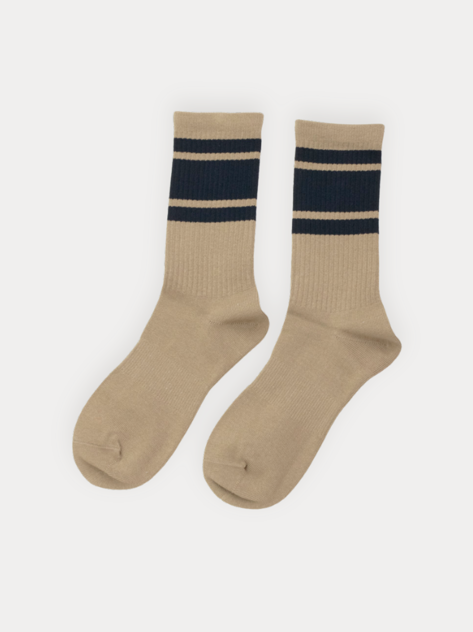 A pair of ribbed crew socks in tan with two bold navy stripes at the cuff.