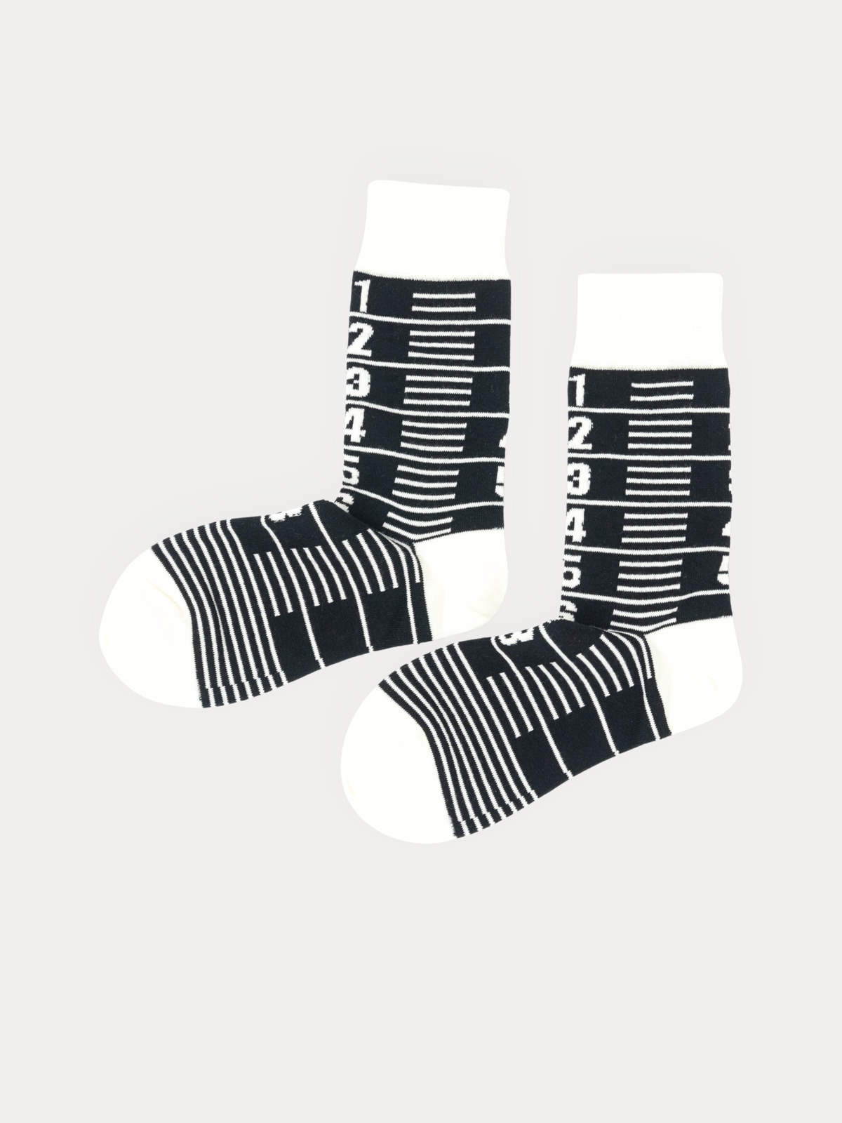 Pair of Number Socks in black and cream, one standing upright, one laid flat to show the striped foot.