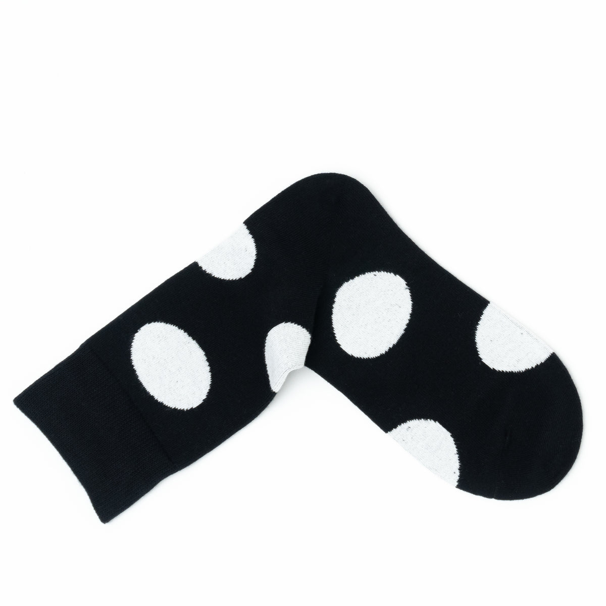 Single black crew sock folded into a V shape, showing the large white polka dot pattern.