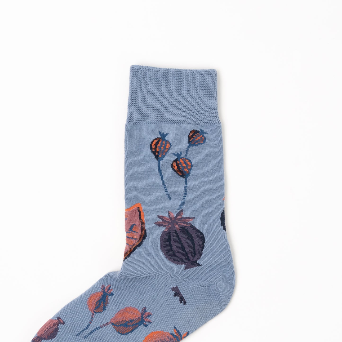 Close-up of a folded sock's cuff and leg, showing small hanging poppy pods on dusty blue fabric above a larger plum pod.