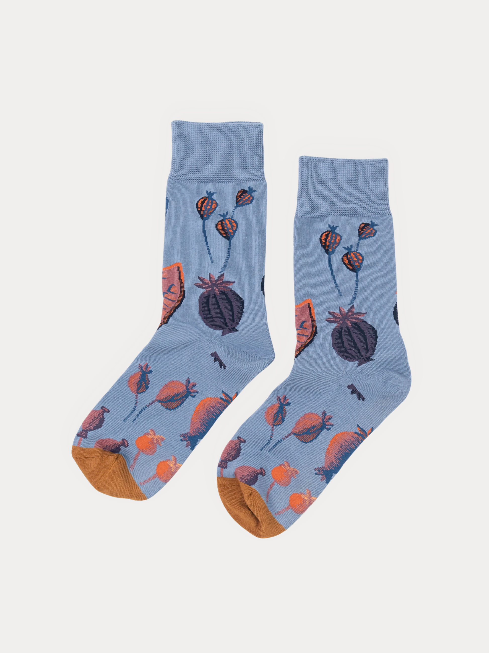 A pair of light blue crew socks with a whimsical pattern of orange poppy pods and small black insects, finished with orange toes, shown on a light gray background.