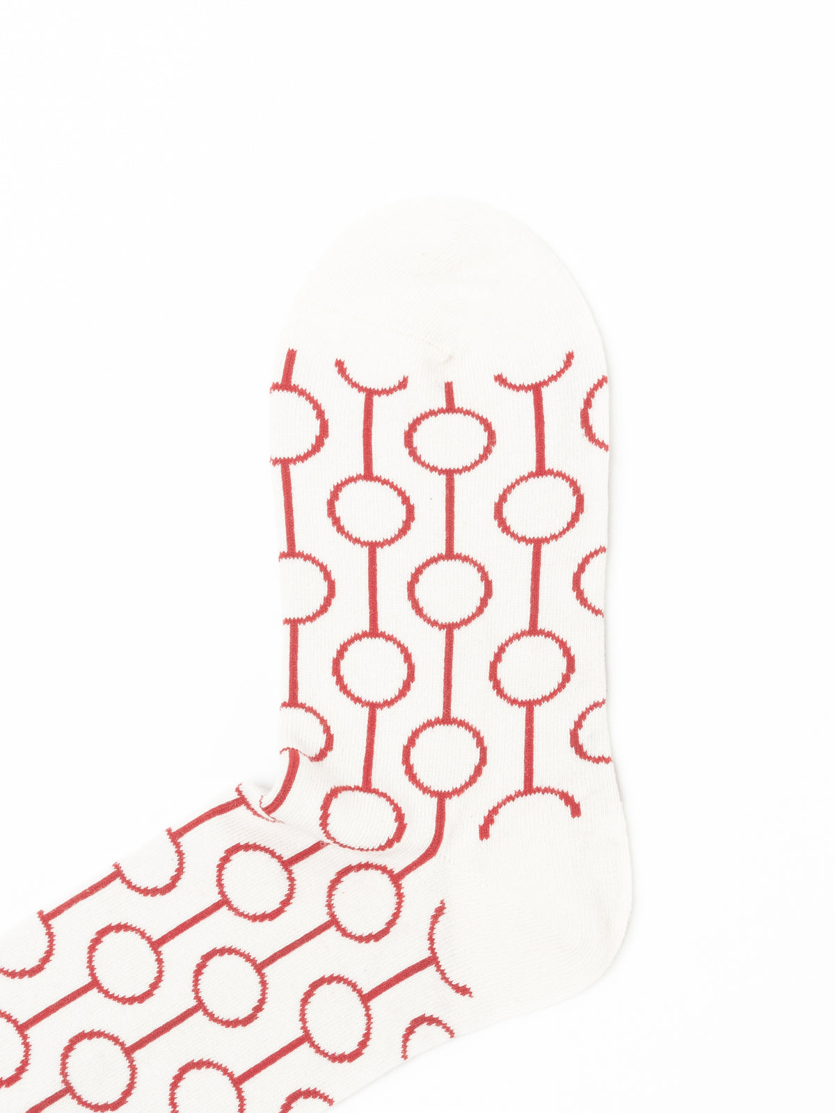 Single cream sock angled to show the heel and instep, where the circle-and-line pattern shifts direction.