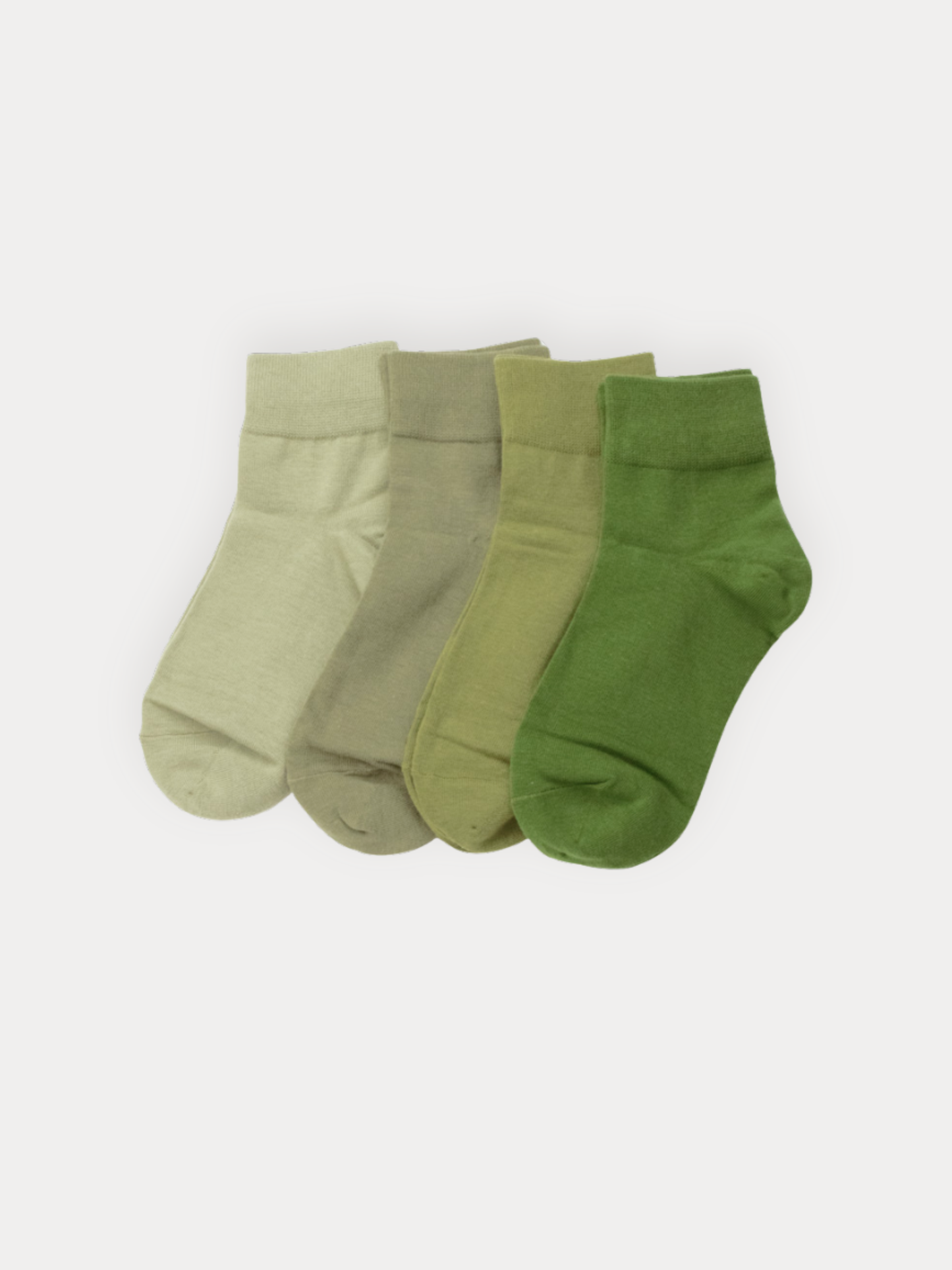  Four ankle socks in four shades of green, ranging from light sage to forest green.