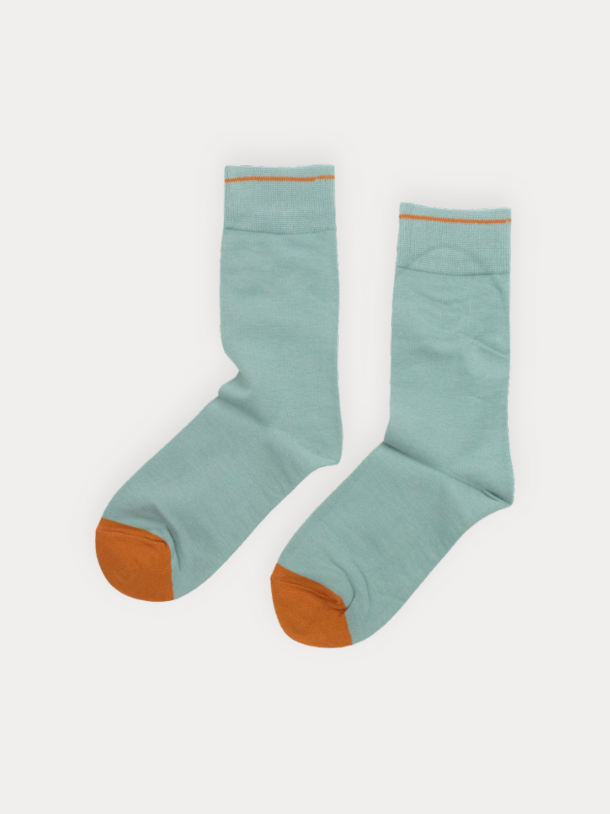 Pair of light blue socks with orange toes and cuffs on a white background