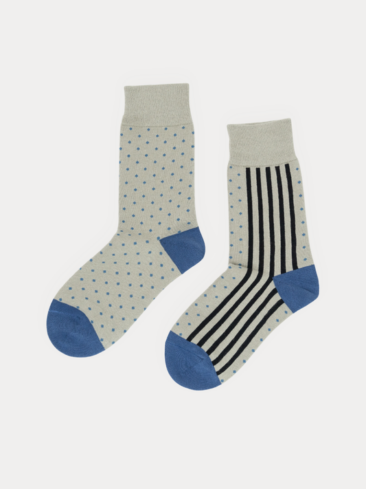 Pair of grey crew socks with blue heels and toes, one in a dot print and one in a vertical stripe print, laid flat side by side.