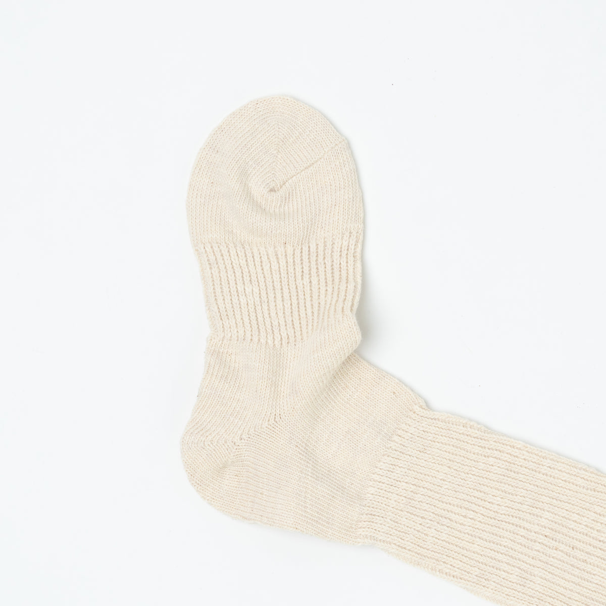 Close-up of the sock's heel and foot, with the ribbed knit texture visible in raking light.
