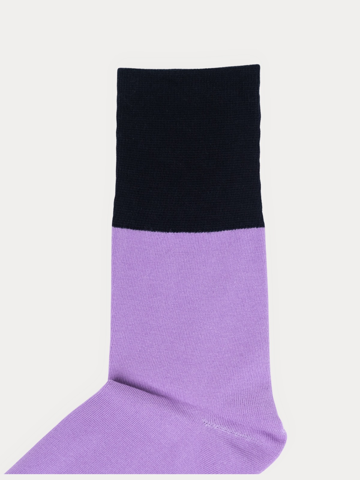 Close-up of the black cuff and lavender leg of a folded sock, showing the ribbed knit texture.