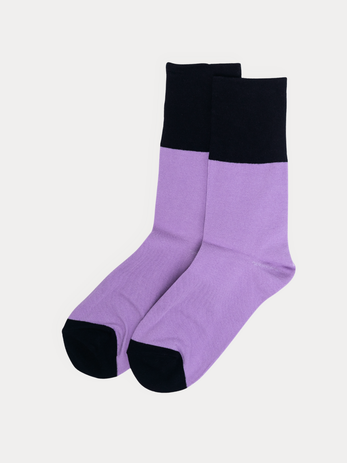 A pair of lavender crew socks with black cuff and toes, laid crossed over each other on a light gray background.