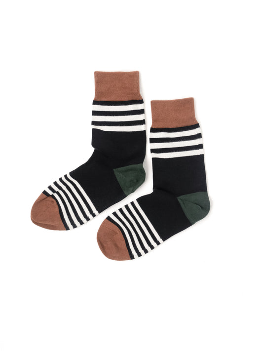 A pair of crew socks with a color-blocked design. The socks feature a black body with white horizontal stripes near the cuff, a solid brown toe and cuff, and a dark green heel section.