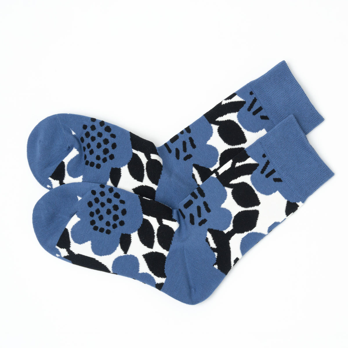 Pair of blue crew socks folded together, showing the bold black and white floral pattern from heel to toe.