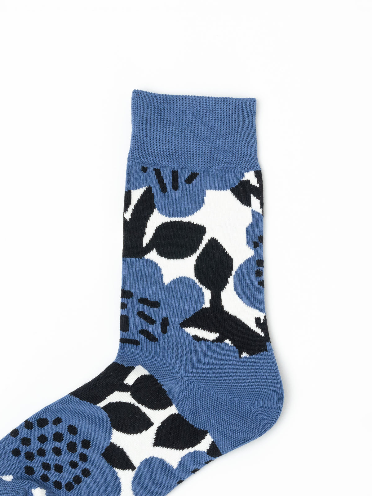 Close-up of a blue crew sock with a bold black and white floral pattern and ribbed cuff.