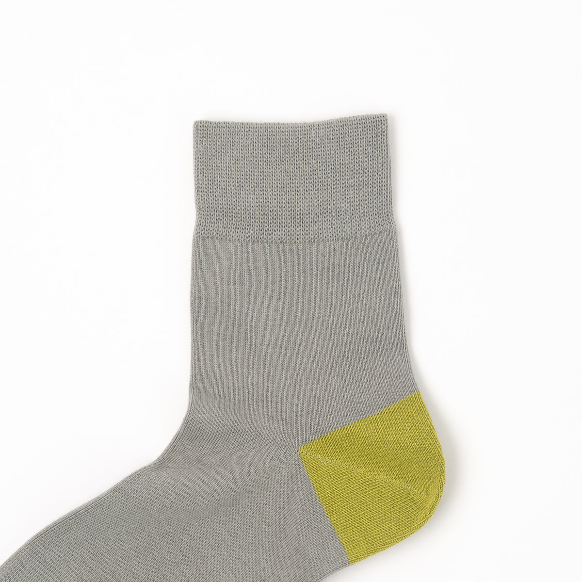 A single gray knit sock with a contrasting yellow-green heel and toe section, shown against a plain white background.